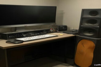 A home recording setup with microphone, laptop audio waveforms, and audio gear for ai voiceover jobs.