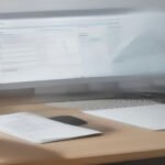 A modern remote workspace setup featuring a laptop displaying data annotation task workflows for CrowdGen jobs.
