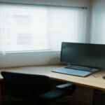 Laptop screen displaying freelancer payment records and invoice documents on a desk.