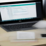 Digital product creator workspace showing a laptop and strategy planner for online store marketing.