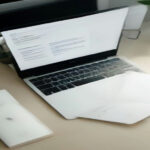 A laptop open to a resume document on a clean, professional workspace desk.