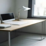 A clean home office setup showing a laptop displays an account management interface on a tidy wooden desk.