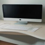 Digital product creator workspace with laptop displaying Gumroad seller dashboard and product metrics.