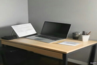 A modern minimalist desk with a laptop and notebook set up for remote internet rating evaluation work.