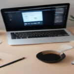 A modern home workspace with a laptop screen showing research data and survey analytics on a clean wooden desk.
