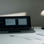 Modern workspace with laptop showing user research dashboard and professional note-taking setup.