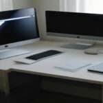 Home office workstation with dual screens displaying structured quality evaluation guidelines.