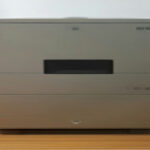 A modern home-lab mini server connected to networking gear for Docker container hosting.