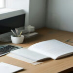 A professional remote work setup featuring a laptop and study notes for online tutoring.