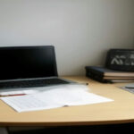A modern laptop setup on a tidy wooden desk arranged for online tutoring sessions.
