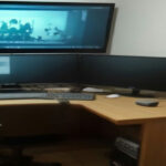 Video creator workstation showing video editing equipment and analytics on a screen.