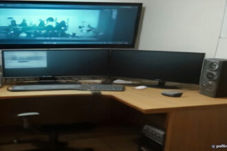 Video creator workstation showing video editing equipment and analytics on a screen.